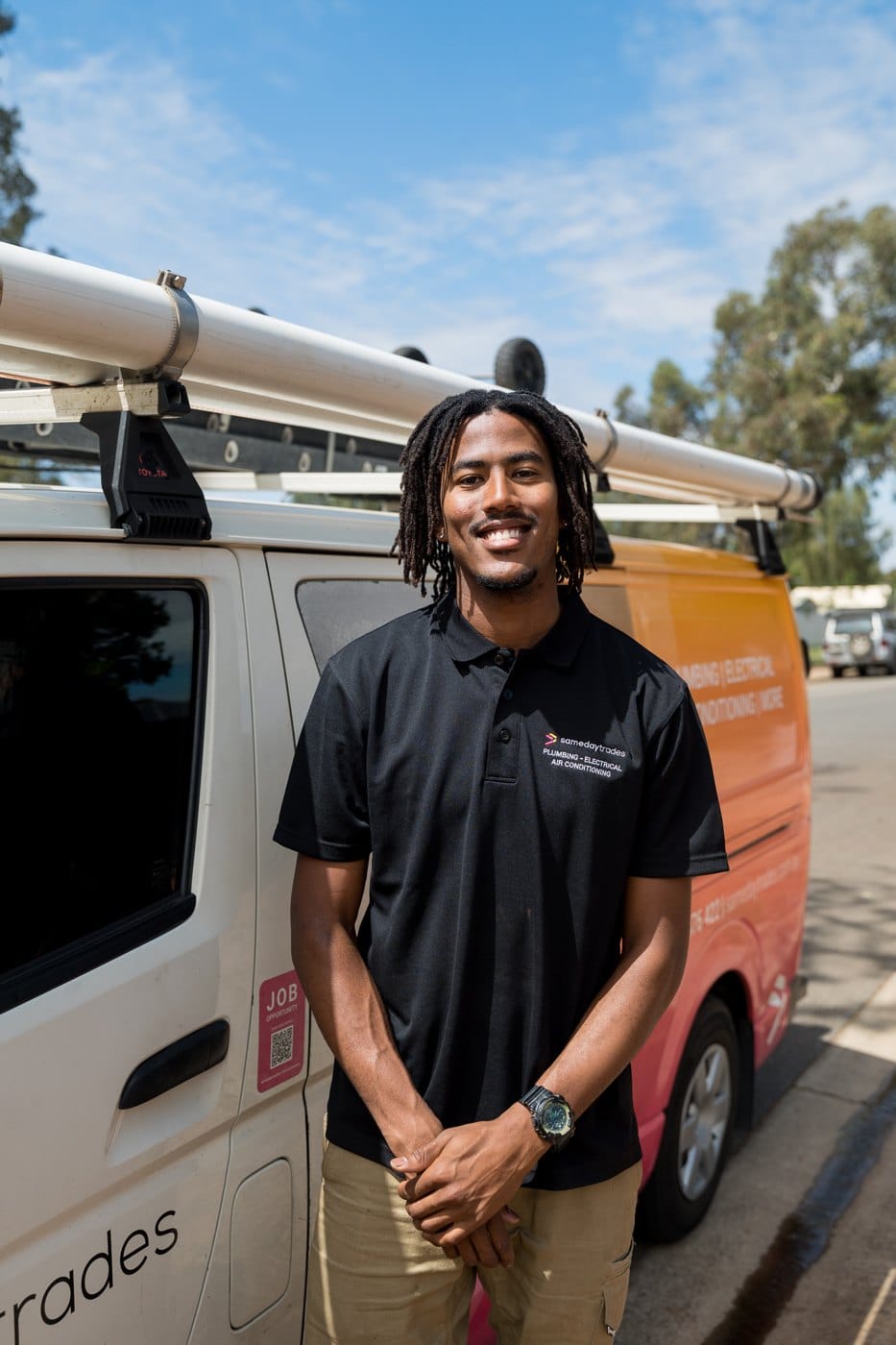 Same Day Trades air conditioning technician in front of van
